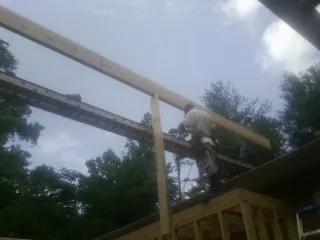 Carpenter setting a ridge beam over a new addition frame — Ice Dam Removal by Roofing Brothers in Lake Zurich