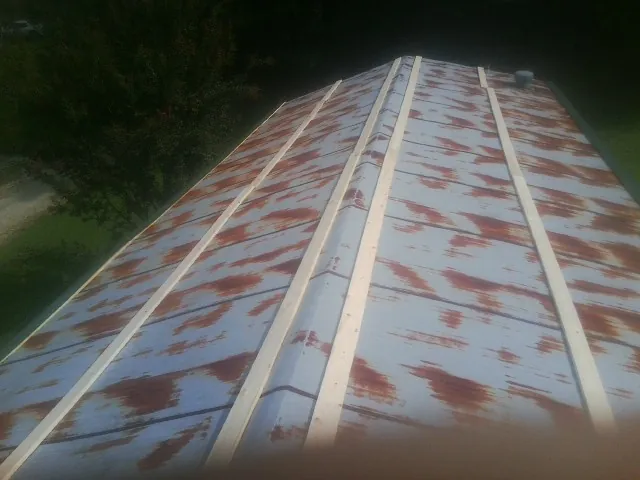 Rusted metal roof panels with new wood purlins before replacement — Storm Damage Roof Repair in Lake Zurich by Roofing Brothers