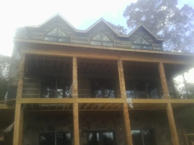 Dormers and porch framing on a large log home under construction — Roof Coating work by our crew in Lake Zurich