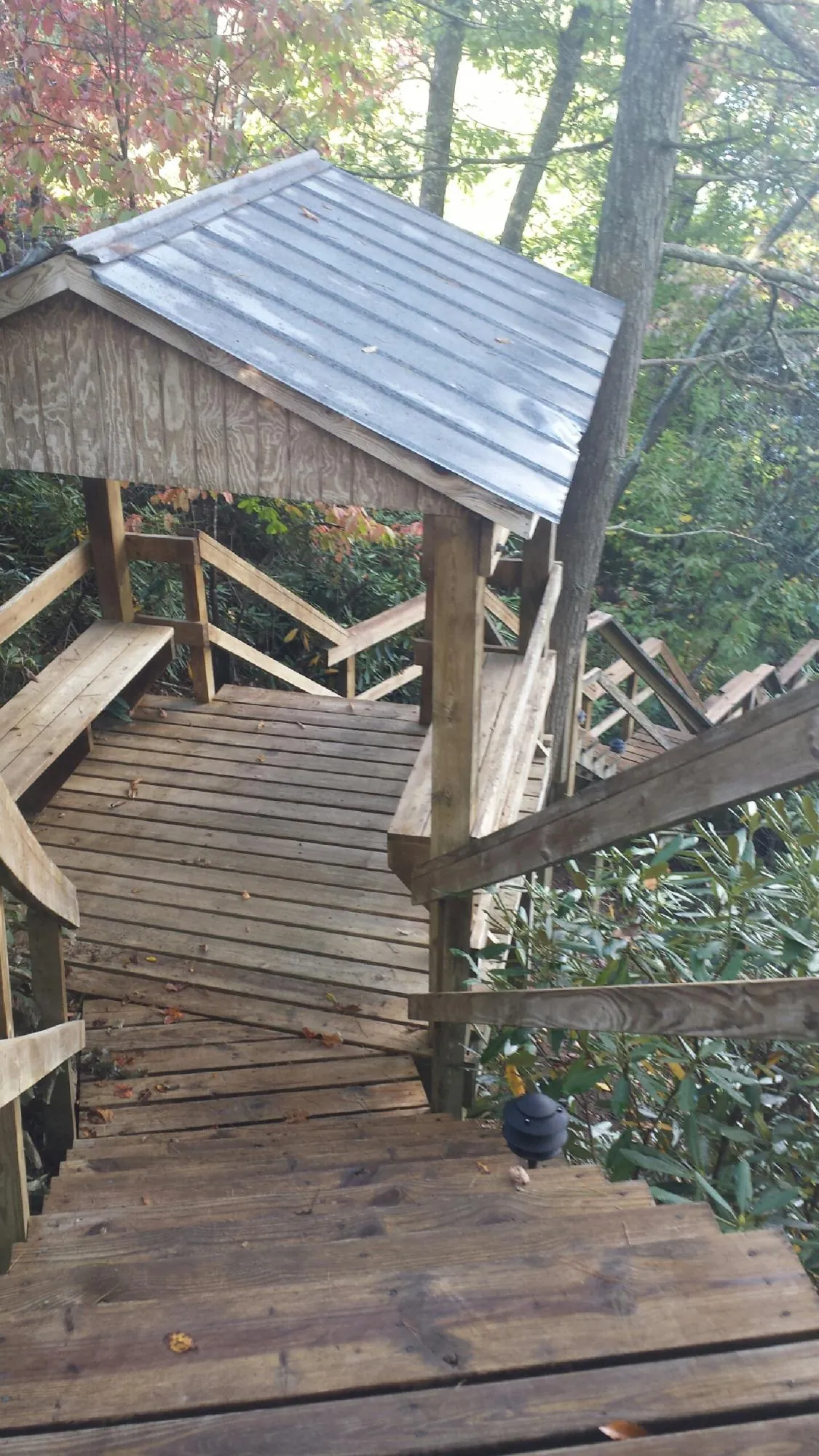 Metal roofed shelter over wooden steps on a wooded walkway — Skylight Repair & Installation work by our crew in Lake Zurich